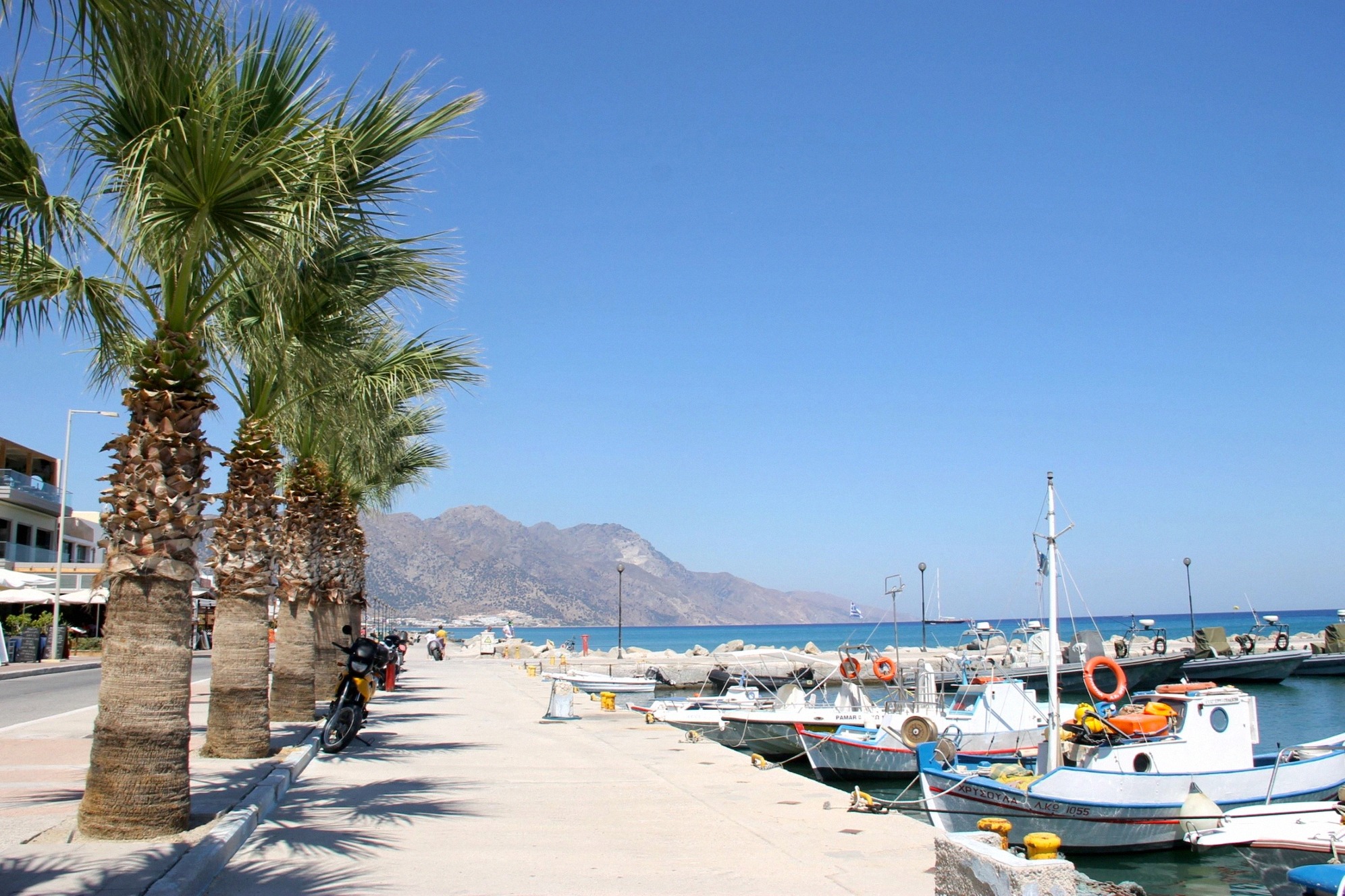 Uferpromenade von Kos mit Palmen und kleinen Booten im Hafen